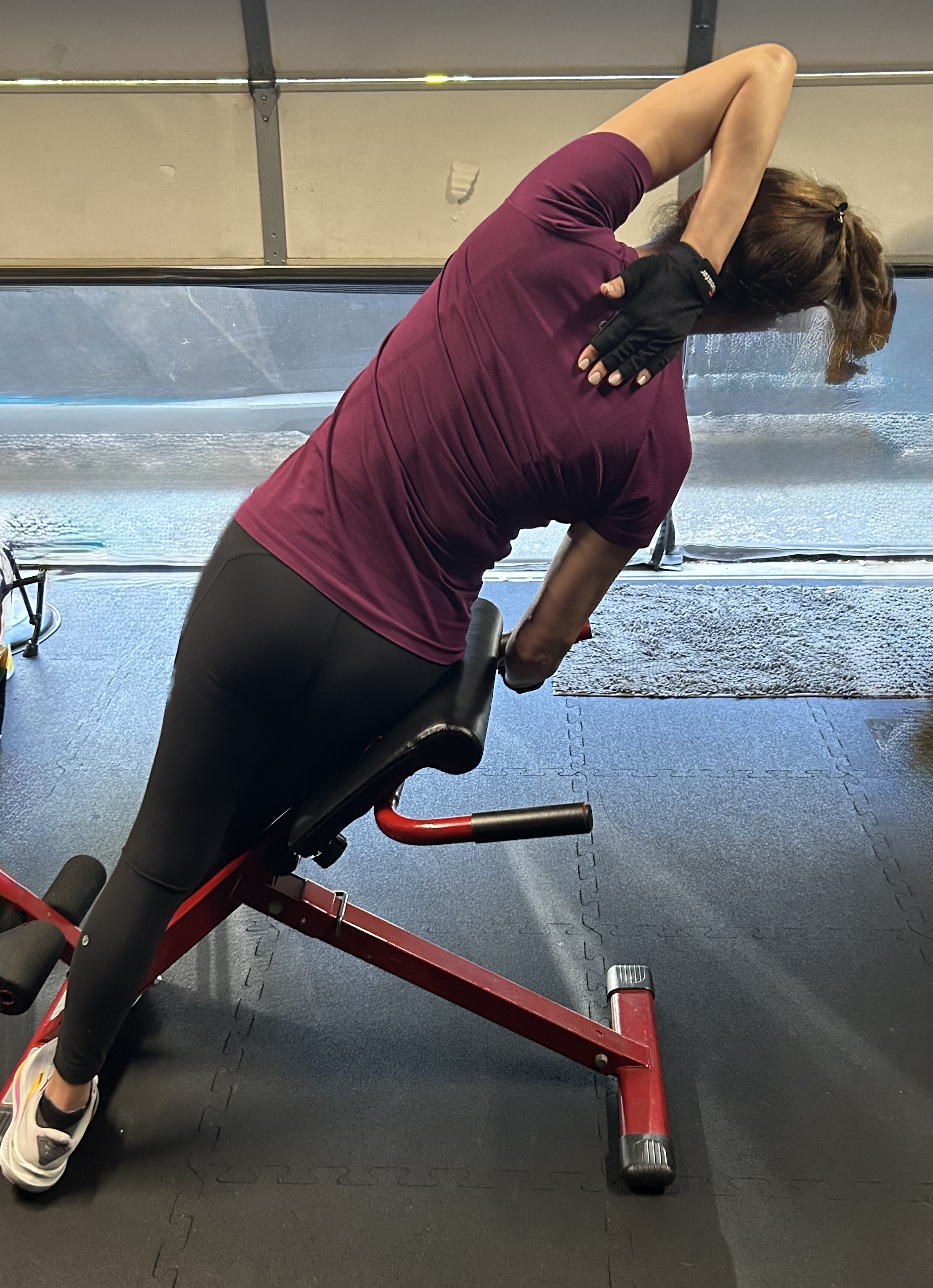 Woman doing side bend stretch on bench