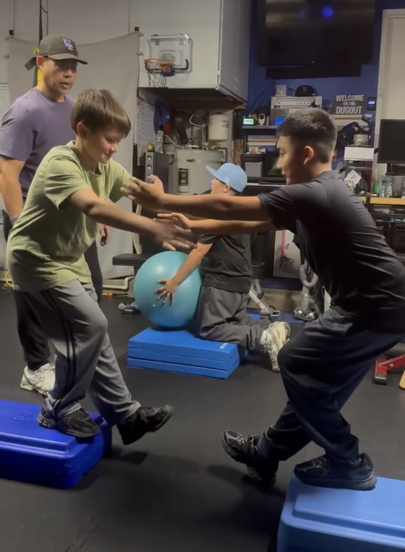 Youth athletes doing balance drill on step boxes in gym